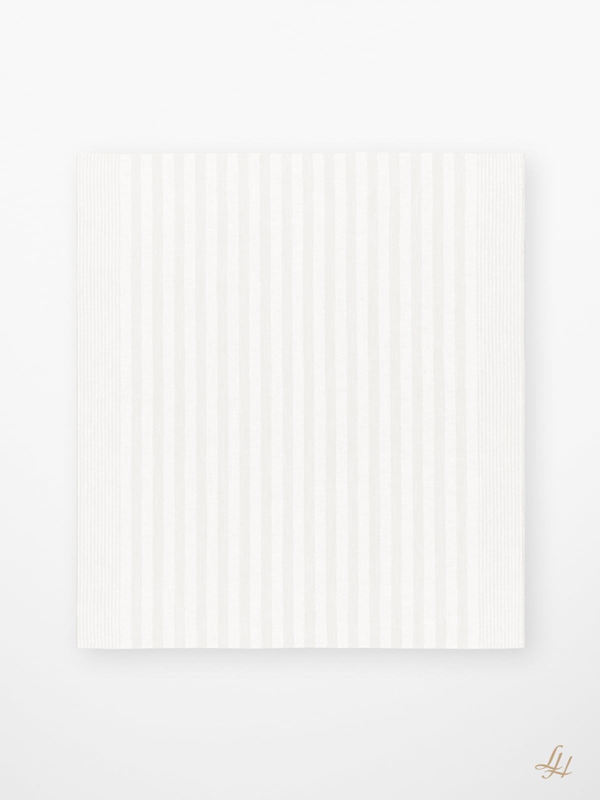 Weißes rechteckiges Papier mit klassischem Streifendesign, platziert auf weißem Untergrund. Ein kleines goldenes LH-Monogramm ziert die untere rechte Ecke.