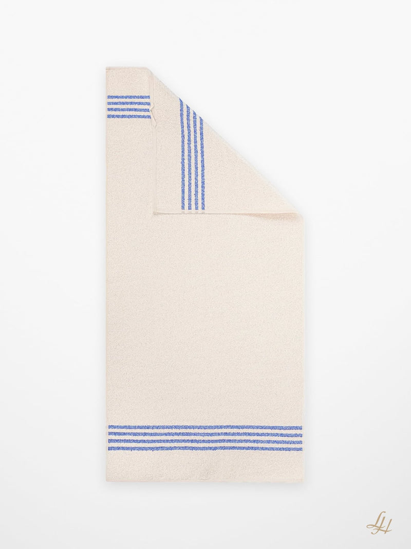 Ein gefaltetes blaues Leinenfrotté-Handtuch mit drei Streifen an beiden Enden, abgebildet auf einem schlichten weißen Hintergrund.