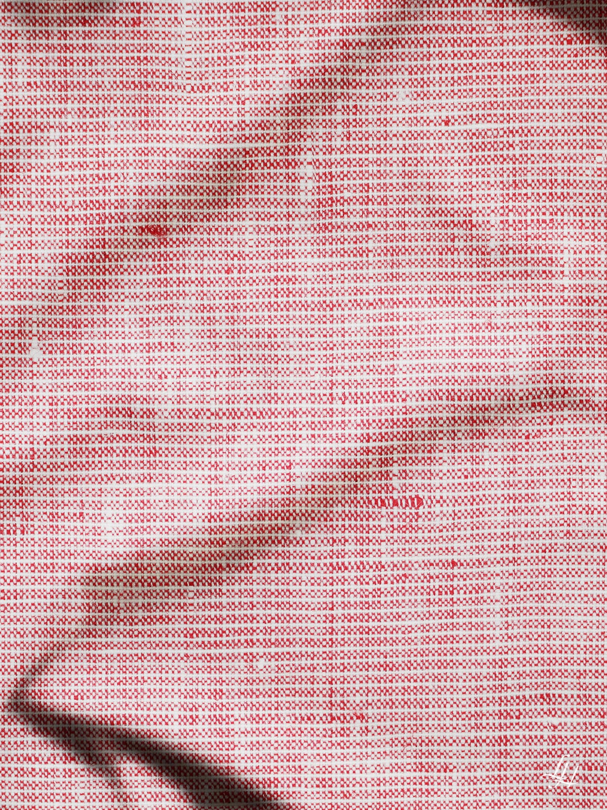 Geknitterte rosa Leinenbettlaken mit feinem Webmuster und dezenten Schatten, die die sanften Falten hervorheben.